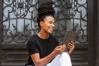 Cheerful woman using tablet, monotone outfits