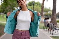 Cheerful woman putting on turquoise jacket