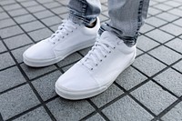 Plain white sneaker, men's footwear on a grey tiled floor