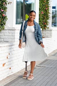 Beautiful amputee woman walking, wearing plain white dress