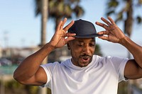 African American man wearing a cap, tipping hat for swag