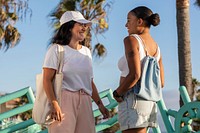 Women hanging out by the beach, mixed race friends enjoying summer