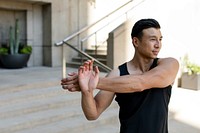 Asian man stretching outdoor in the city 