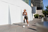Woman with prosthetic leg running on city pavement