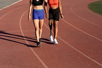 Two athletes walking on a running track 