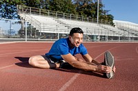 Asian man stretch by the running track 