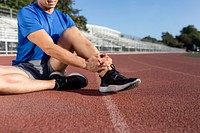 Man getting hurting his ankle and sitting on the track 