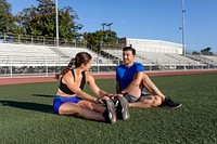 Workout partners stretching together 