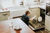 Boy putting dish to dishwasher, household chores for kids