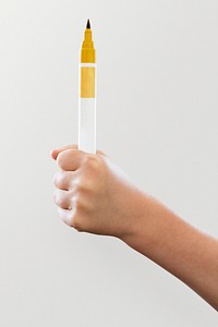 Kid holding yellow color pen psd