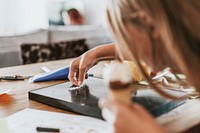 Girl creating text on black letter board