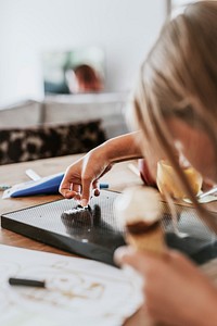 Girl creating text on black letter board