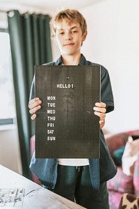 Boy showing black letter board, shop sign