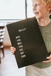 Boy showing black letter board, shop sign