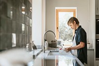 Boy washing dishes, household chores for kids