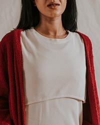 Woman wearing beige cropped top with red cardigan, autumn apparel fashion design