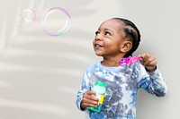 Cute boy blowing soap bubbles in the summer