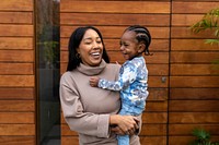 Happy mother and son infront of house