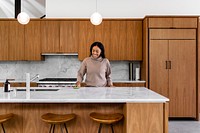 Woman polishing kitchen countertop with sponge