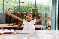 Happy girl doing homework in the kitchen