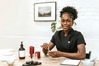 African American woman holding serum bottle in spa