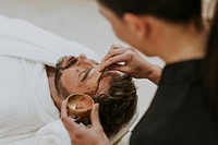 Man getting spa facial mask, self-care photo