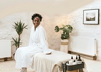 African American woman in bathrobe sitting in spa