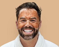 Smiley man in bathrobe with facial mask