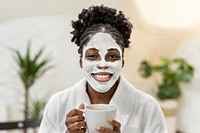 Woman with spa facial mask holding a cup