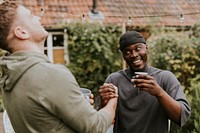 Happy friends arm wrestling with each other at a party