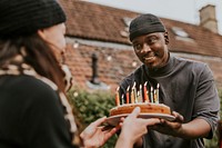 Woman bringing a birthday cake to her birthday friend 