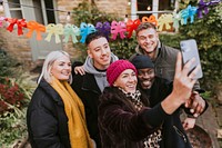 Diverse friends taking a group selfie at a Christmas party 