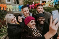 Diverse friends taking a group selfie at a Christmas party 