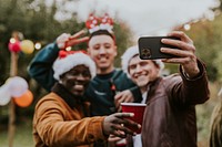 Diverse friends taking a group selfie at a Christmas party 