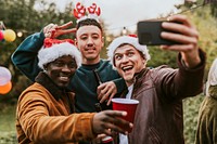 Diverse friends taking a group selfie at a Christmas party 