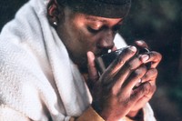 Man keeping warm with hot chocolate, a beanie, and a shawl