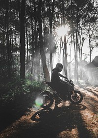 Man on a motorbike in a forest in Indonesia