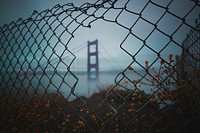 View of the Golden Gate Bridge, San Francisco, United States through a broken wire fence