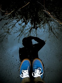 Man taking a photo of his own shadow in a puddle