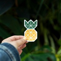 Pineapple sticker held up outdoors