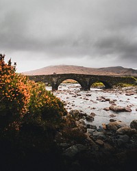View of arch bridge crossing a river in Scottish Highlands, Scotland