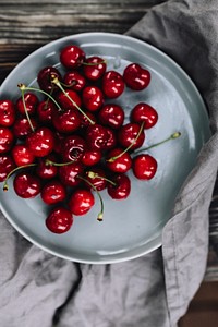 A plate with red cherries. Visit <a href="https://kaboompics.com/" target="_blank">Kaboompics</a> for more free images.
