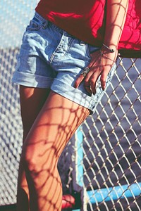 Woman standing by a fence. Visit <a href="https://kaboompics.com/" target="_blank">Kaboompics</a> for more free images.