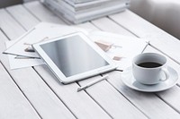 Tablet and a coffee cup on a table. Visit <a href="https://kaboompics.com/" target="_blank">Kaboompics</a> for more free images.
