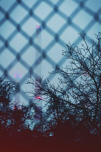 Industrial chimneys through a fence. Visit Kaboompics for more free images.