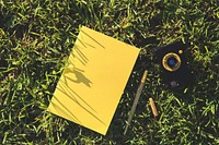 Notebook in the grass. Visit <a href="https://kaboompics.com/" target="_blank">Kaboompics</a> for more free images.