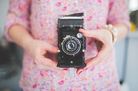 Woman holding vintage analog film camera. Visit <a href="https://kaboompics.com/" target="_blank">Kaboompics</a> for more free images.