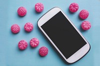 Phone and pink candies. Visit <a href="https://kaboompics.com/" target="_blank">Kaboompics</a> for more free images.