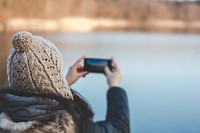 Woman taking a photo of a lake. Visit <a href="https://kaboompics.com/" target="_blank">Kaboompics</a> for more free images.
