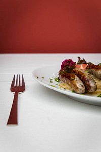 A fork and a plate of a sausage dish